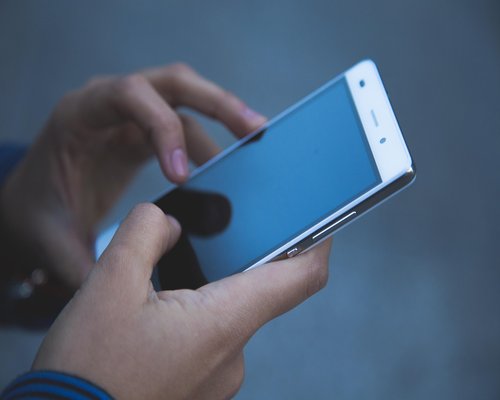 Person hands using a smartphone with warm screen temperature filter enabled